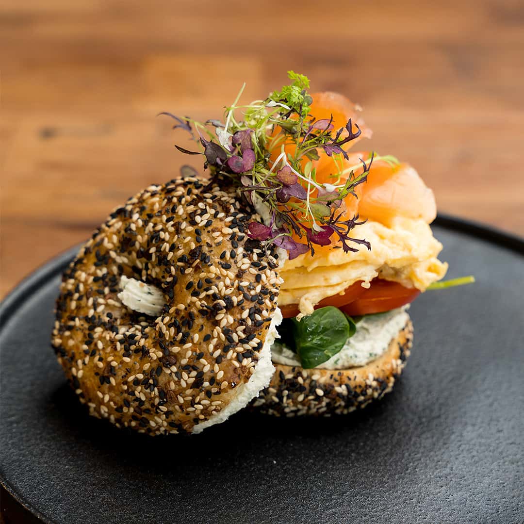 Gourmet bagel sandwich with smoked salmon, cream cheese, and microgreens at Thirty Five Stirling café in Thebarton, Adelaide.