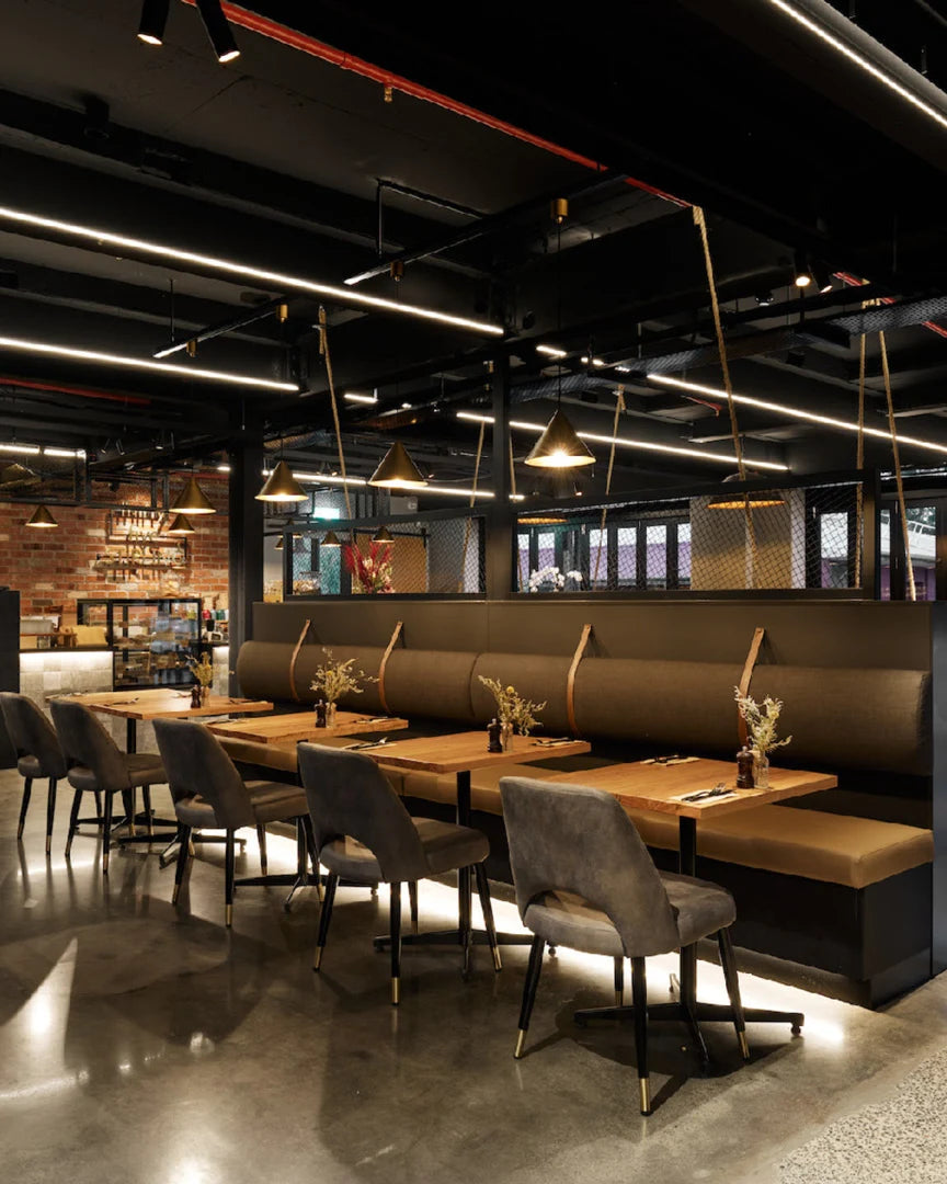 Stylish café and event space interior at Thirty Five Stirling in Thebarton, featuring exposed brick, moody lighting, and communal seating.